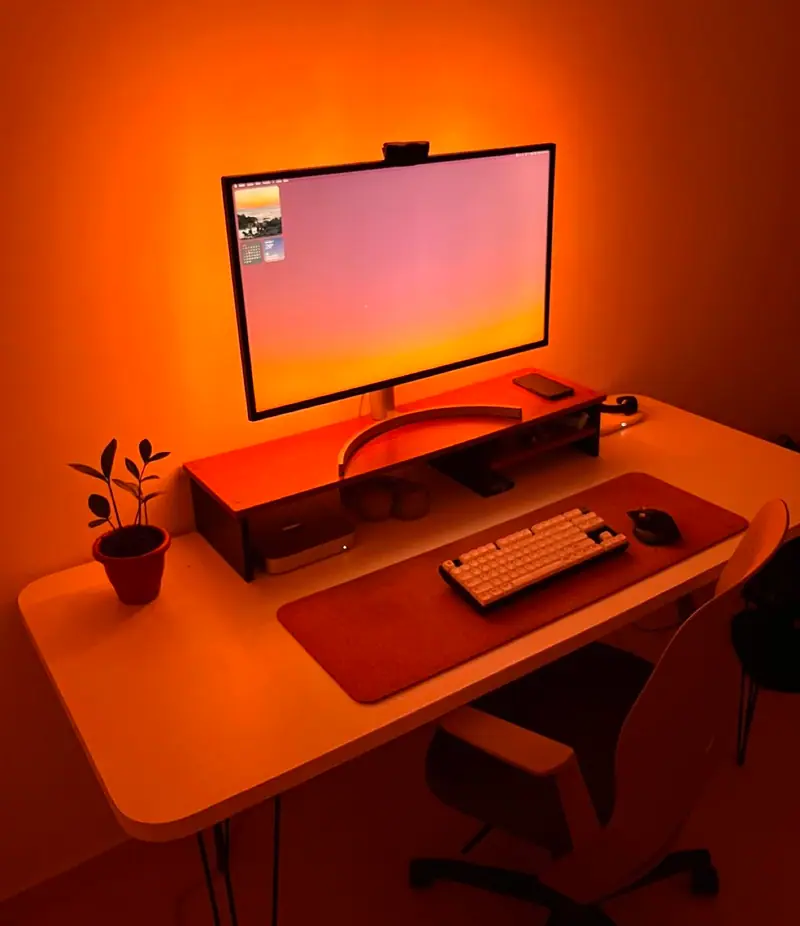 Escritorio con monitor iluminado por una luz naranja